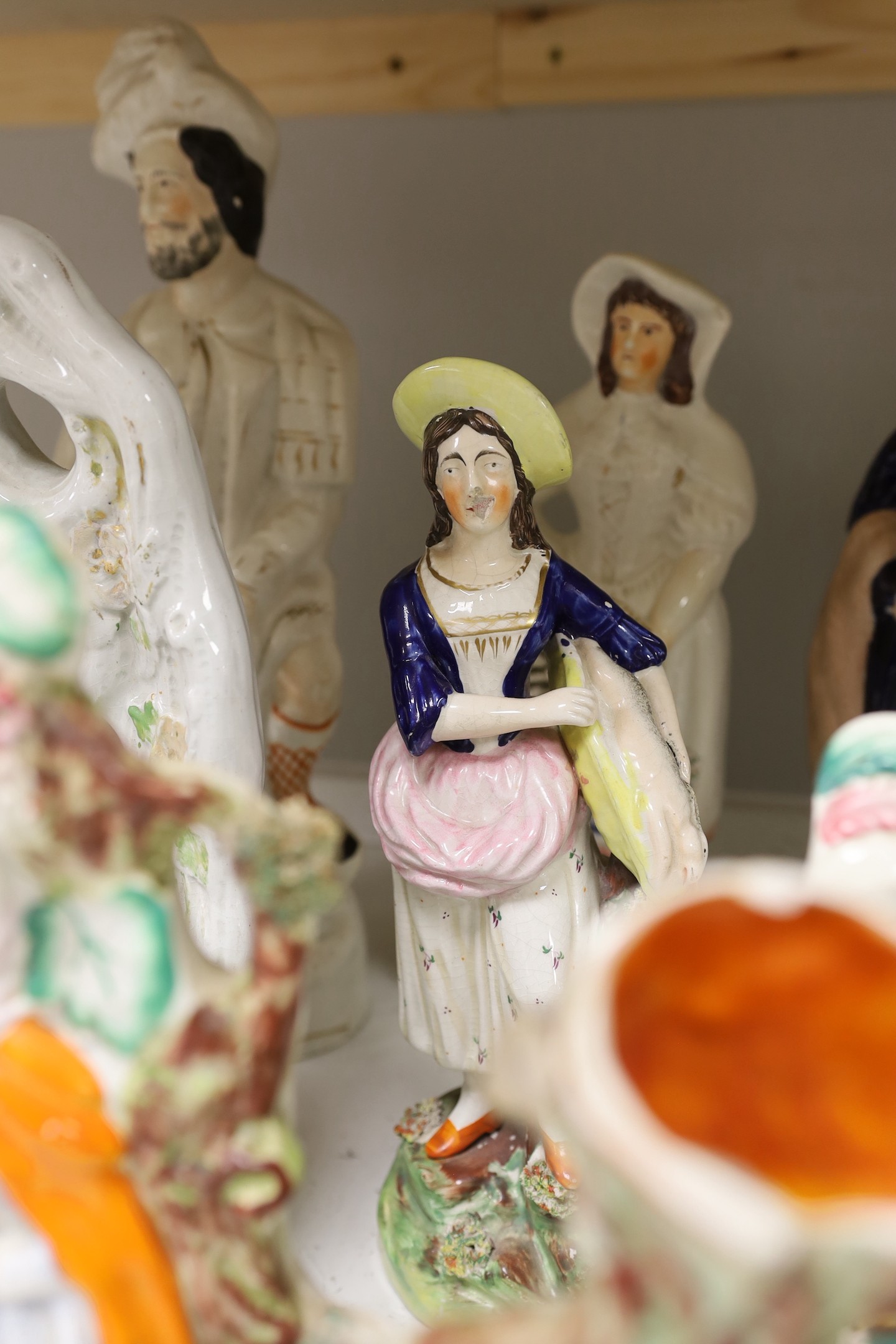A group of Staffordshire pottery and porcellaneous figures and groups, The tallest 42 cm